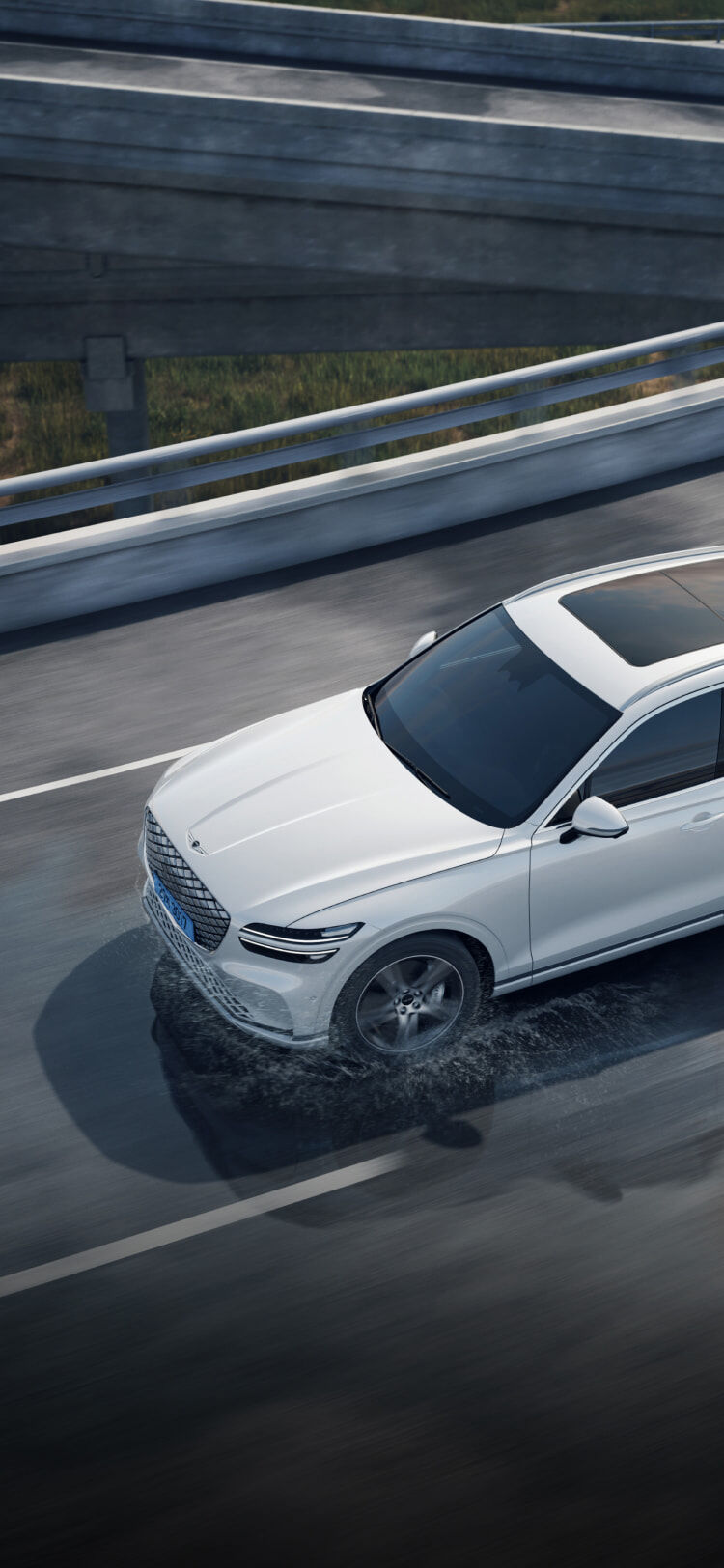 The Electrified GV70 is shown driving on snowy, muddy, and sandy roads.